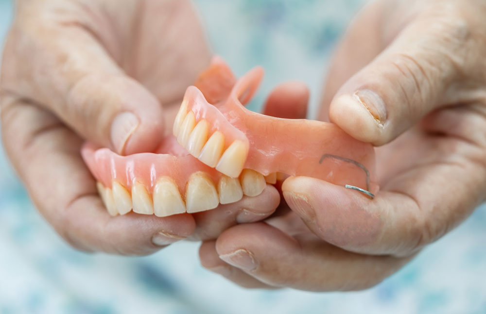 Partial denture which is also flexible is held in the hands shows adjustment 