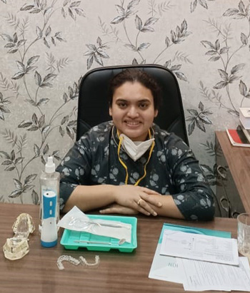 Dr. Arimeeta Chakraverty, the best dentist in Kolkata as an oral and maxillofacial surgeon is sitting